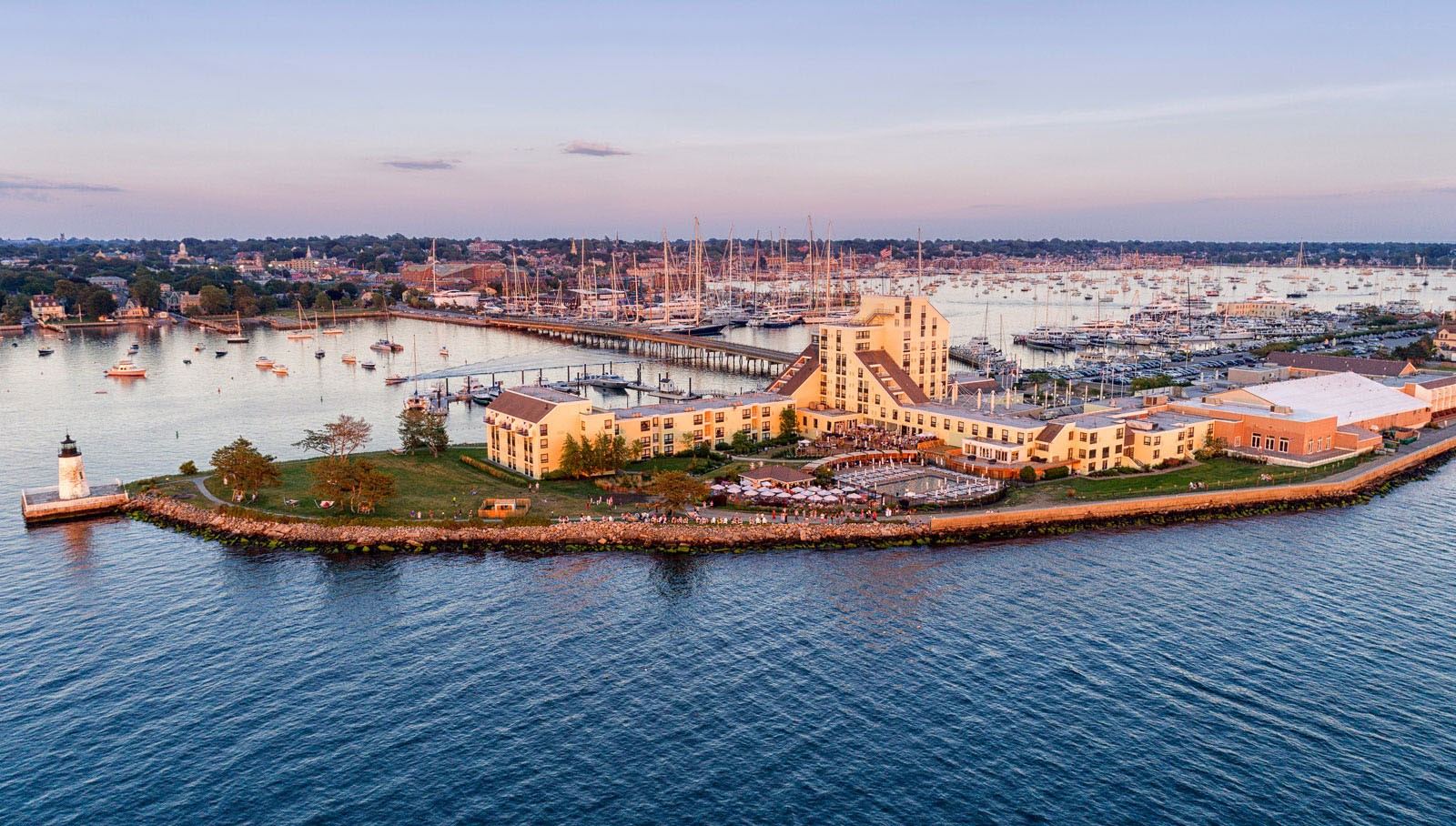 Newport Harbor Island Resort on Goat Island at sunset, with Newport Harbor behind it